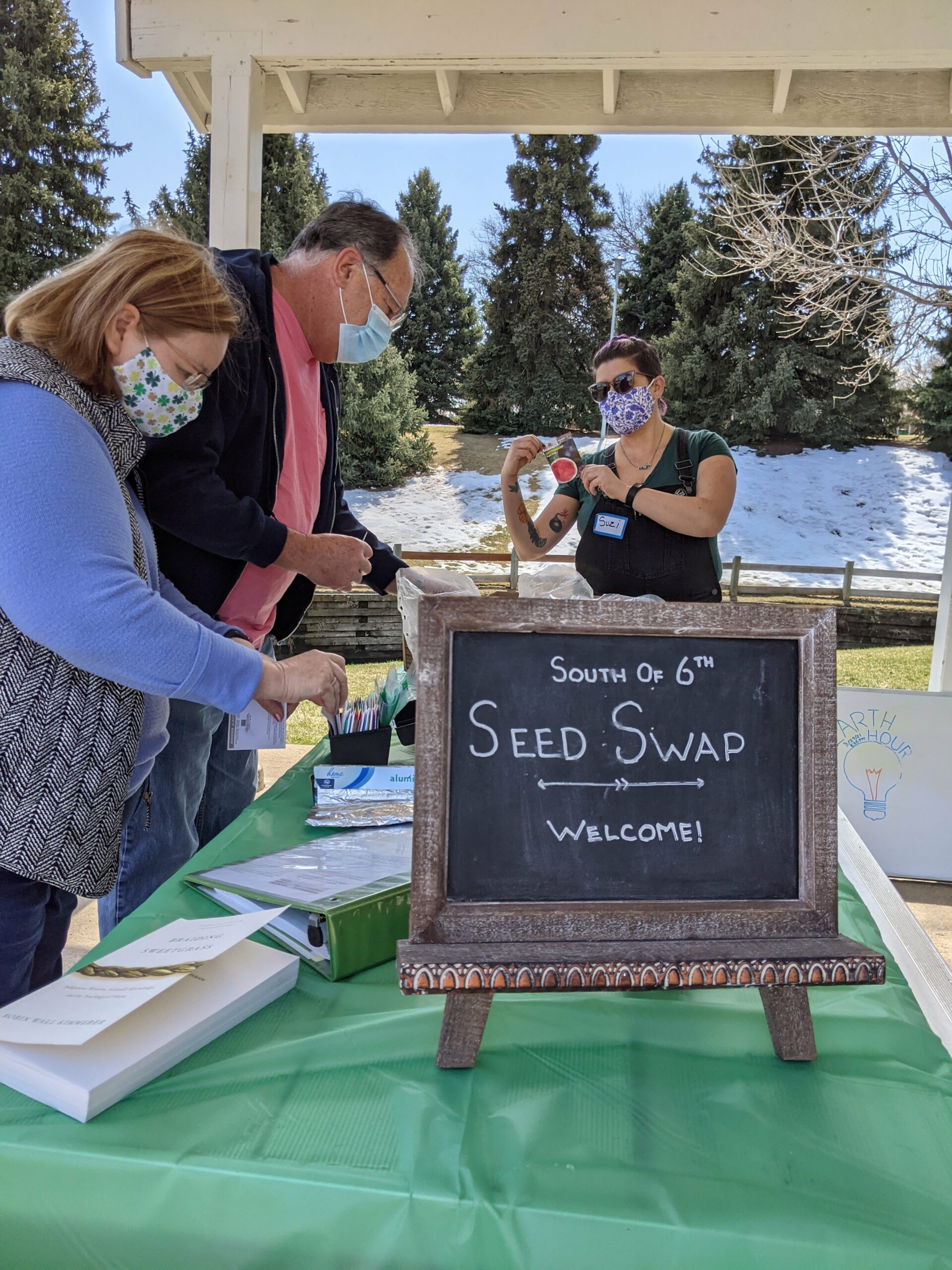 Neighbors look through the many seed packets contributed to the event.